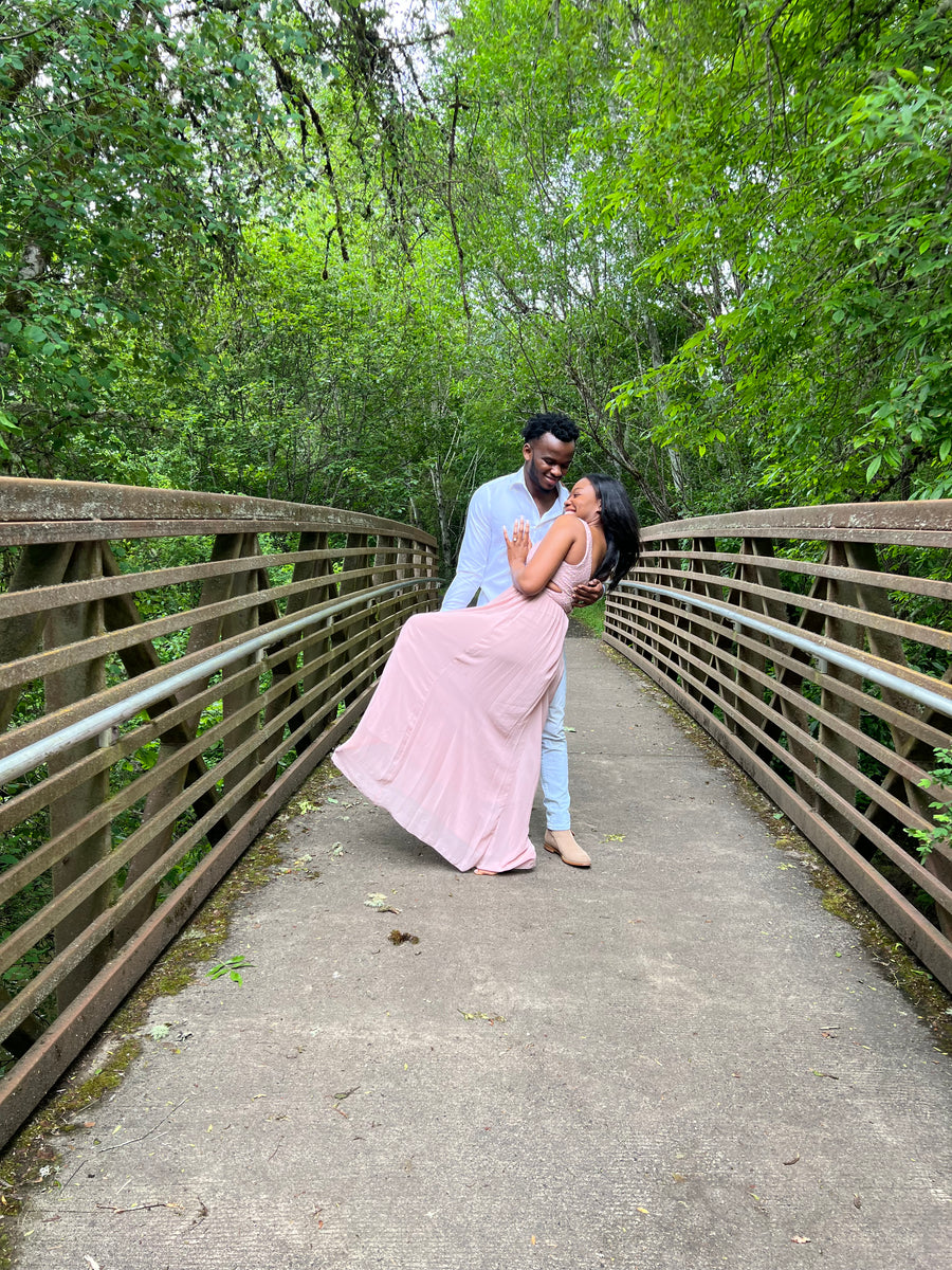 A couple dancing on a wooded bridge